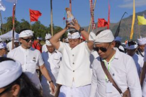 Pj. Gubernur Bali, S.M. Mahendra Jaya menyunggi tirta amreta yang didapat dengan memohon di tengah Danau Batur usai upacara pakelem.